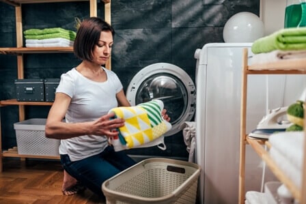 woman takes clothes from dryer