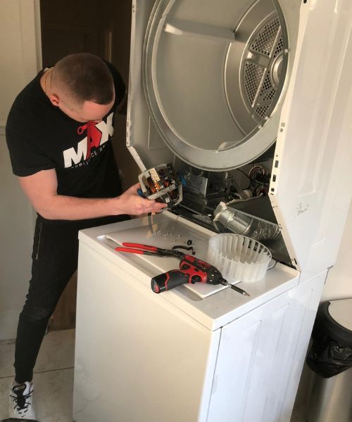 technician holding part for dryer, hard at work